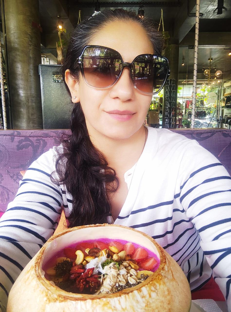 Rucci at a Bali café holding a coconut bowl of medicinal foods